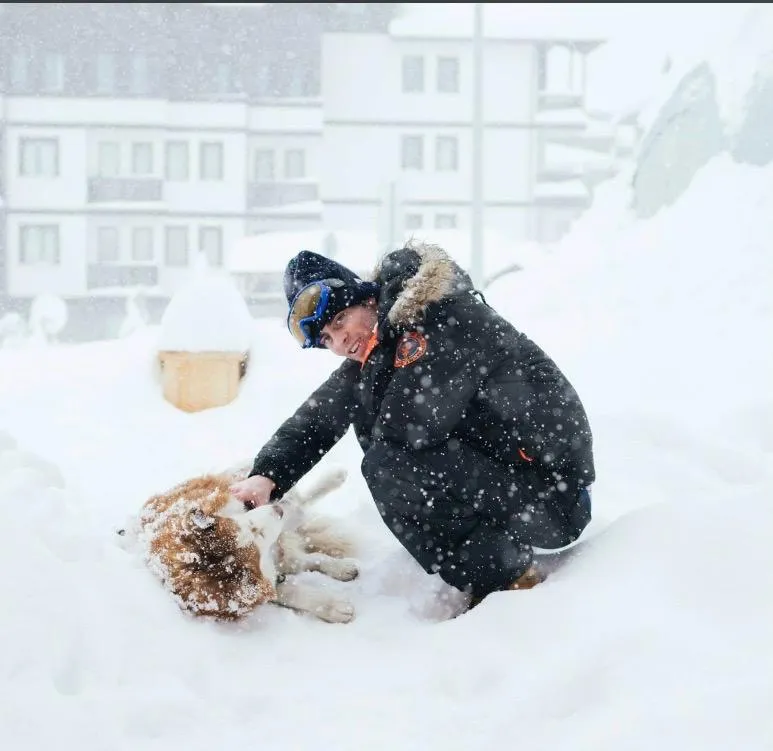Carlo jugando con un husky en la nieve